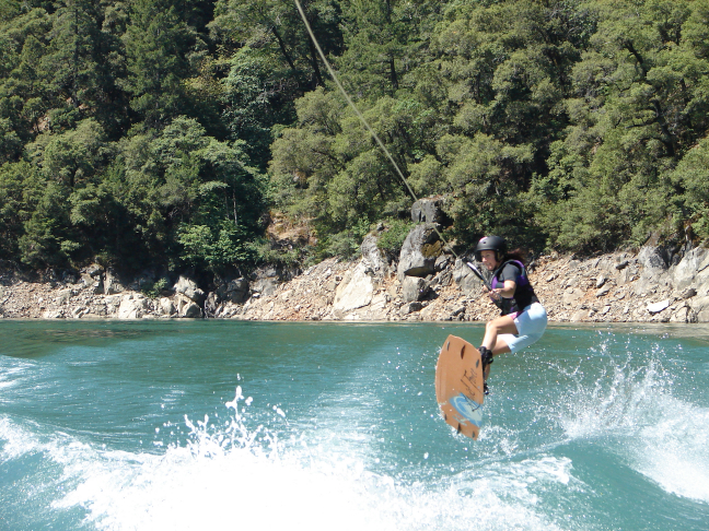 Susie jumping the wake on wakeboard